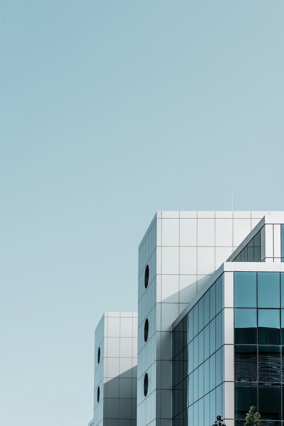 Modern office building with geometric white panels and porthole windows.